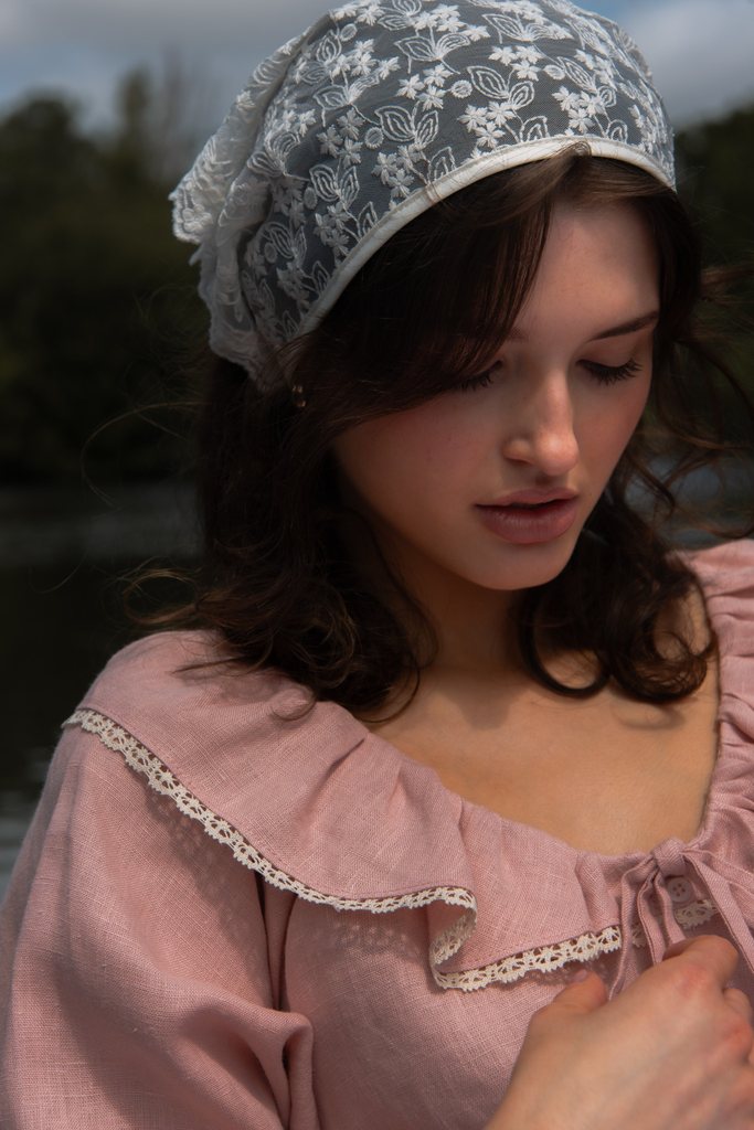 Soft natural light beauty portrait with pink bonnet photographed by Lucy Rappolt