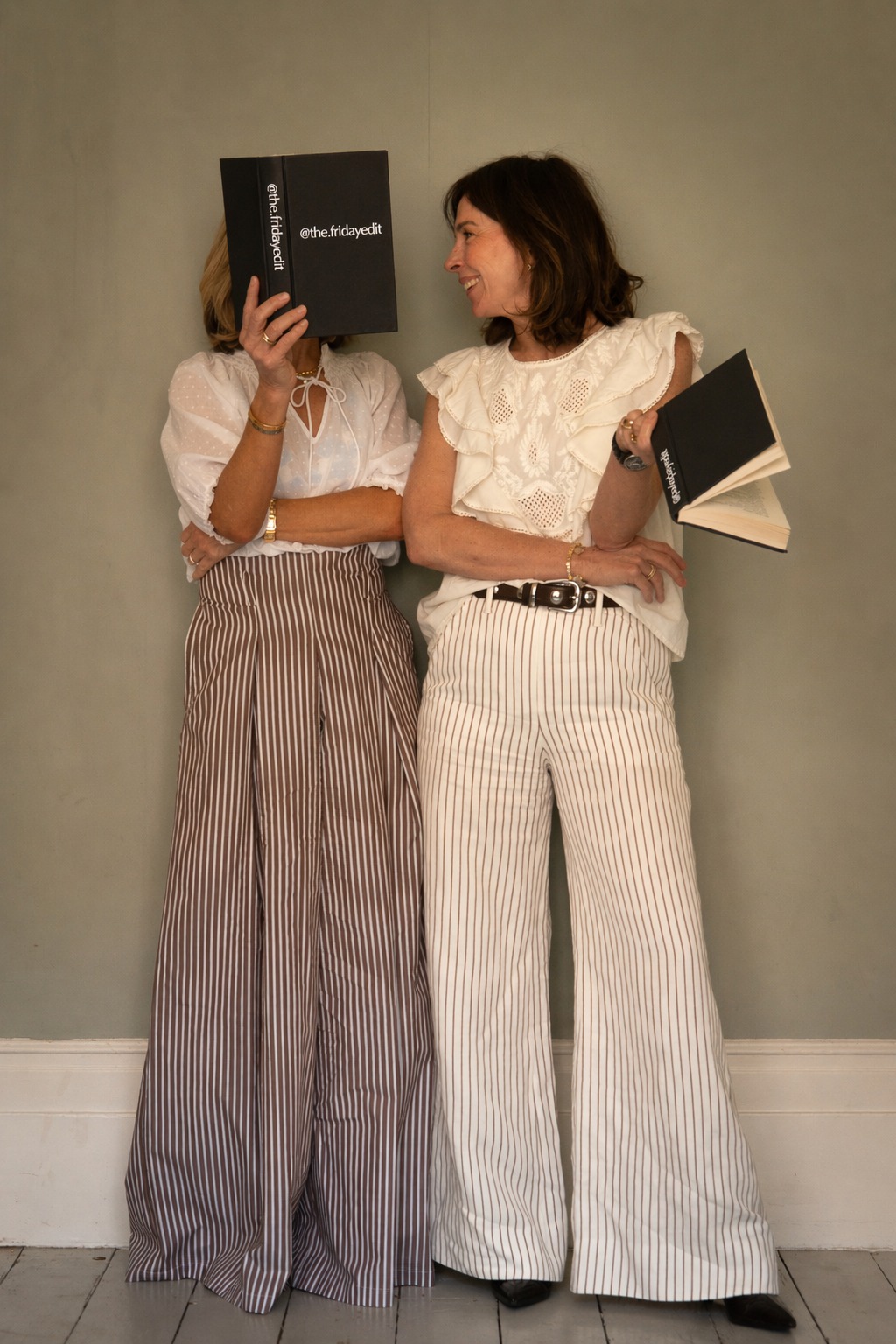 Playful editorial portrait of two women with books